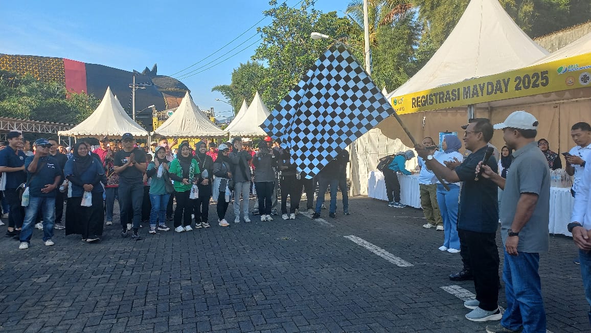 JALAN SEHAT: Kadisnaker Thomas Wunang Tjahjo memberangkatkan peserta jalan sehat yang diikuti para buruh.