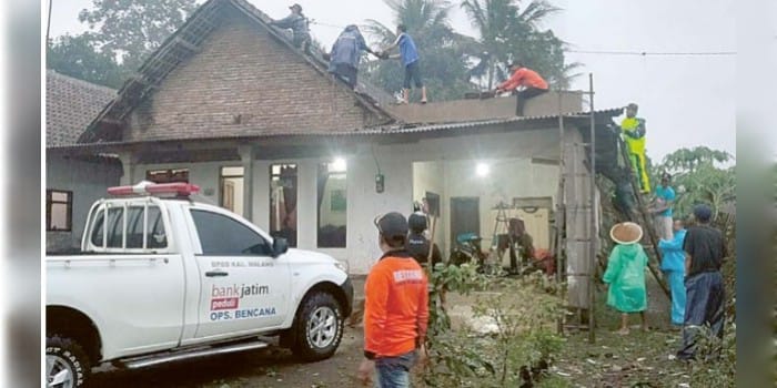 BANTU WARGA: Personel BPBD Kabupaten Malang memperbaiki atap rumah warga Desa Pucangsono, Kecamatan Pakis kemarin.