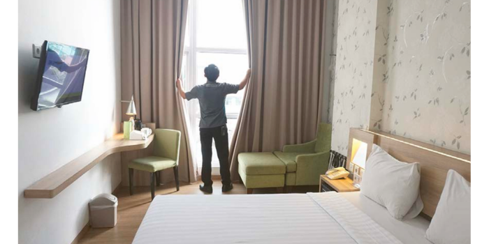 TERIMBAS EFISIENSI: Salah satu pegawai whiz prime Hotel melakukan maintenance di salah satu kamar, kemarin (8/5).
