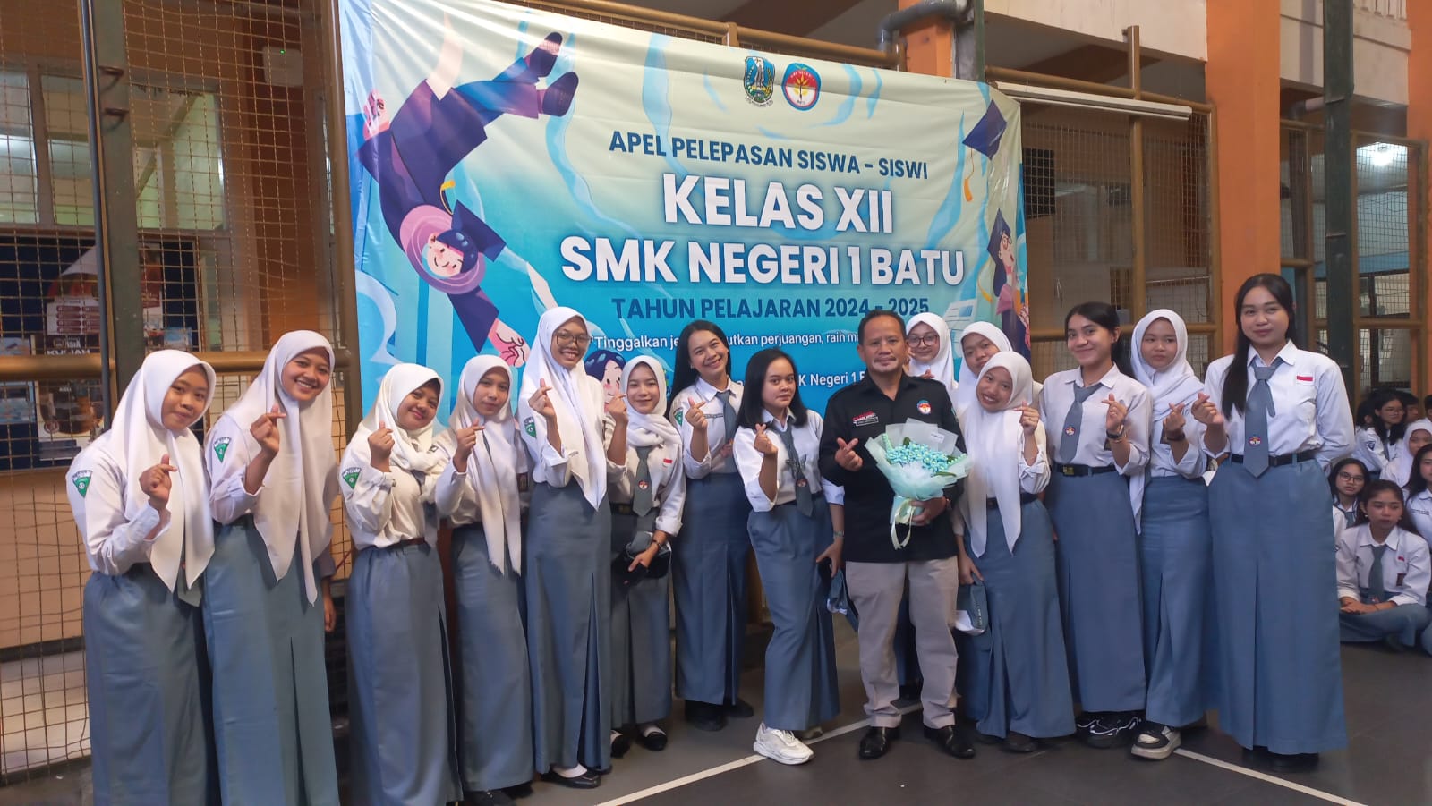 SEDERHANA: Kepala SMKN 1 Batu Joko Santoso menerima buket bunga sederhana dari siswa.