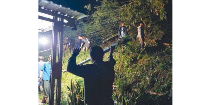 Warga bersama personel BPBD Kabupaten Malang membantu memperbaiki rumah Mursidi yang tertimpa pohon di Dusun Paras, Desa Mulyoarjo (BPBD KABUPATEN MALANG for Radar Kanjuruhan).