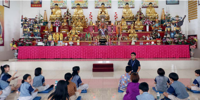 SAMBUT WAISAK: Siswa My Little Island School berdoa di depan patung Buddha pada Jumat (9/5).