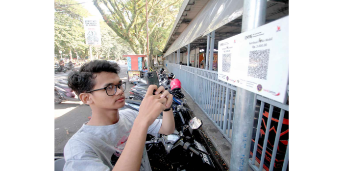 NONTUNAI: Seorang pengendara membayar parkir di kawasan Stasiun Malang Kota Baru menggunakan QRIS kemarin (11/5) siang.