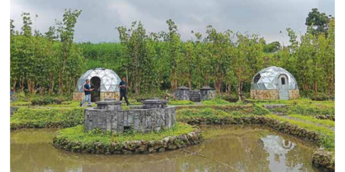 TAMBAH FASILITAS: Dua pekerja di telaga Madiredo melintasi di area prototype glamping kemarin (12/5). (INDAH MEI YUNITA/RADAR KANJURUHAN)