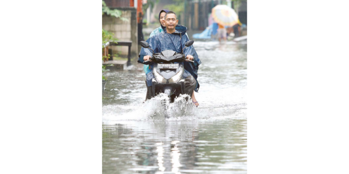 TERGENANG: Warga berusaha menerobos banjir di Jalan Bringin Kulon, Kecamatan Taman, kemarin (12/5) (ANGGER BONDAN/JAWA POS).