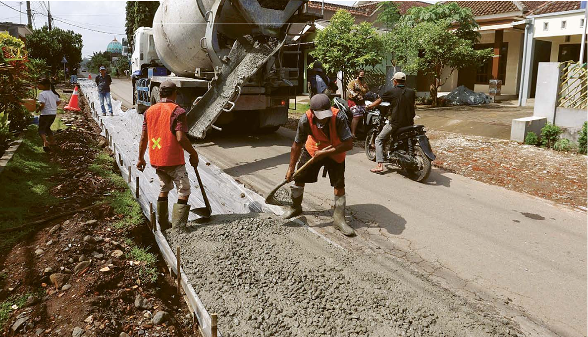 INFRASTRUKTUR: Beberapa pekerja melakukan pengecoran ruas di Jalan Tangkilsari, Kecamatan Tajinan kemarin (13/5). (DARMONO/RADAR MALANG)