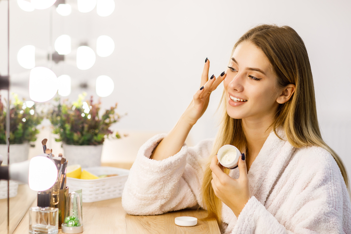 Ilustrasi seorang wanita sedang mengaplikasikan skin care ke wajahnya. (freepik.com)
