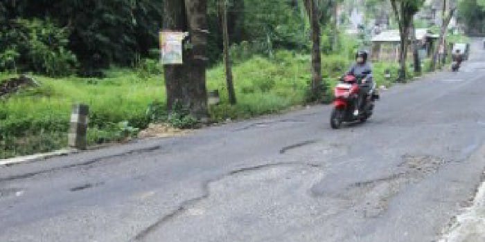 INFRASTRUKTUR: Beberapa pengendara melintasi ruas jalan yang mengalami pengelupasan aspal di Jalan Jurang Akhir, Desa Sidorahayu, Kecamatan Wagir, Jumat lalu (16/5).