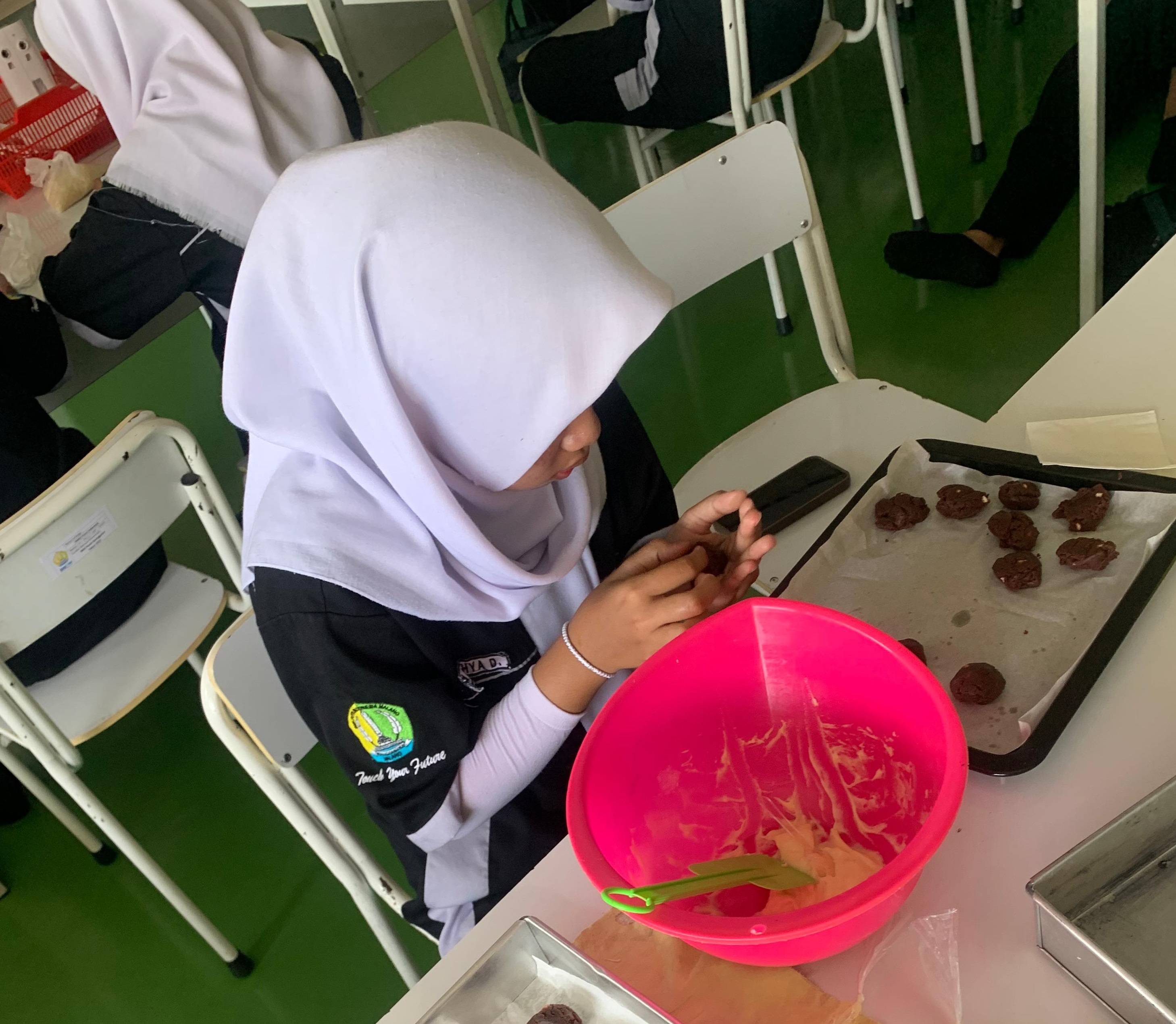 KREATIF: Safina Azeti, siswa SMK Putra Indonesia Malang (PIM) itu justru memanfaatkan kulit jeruk sebagai bahan tambahan membuat kue.