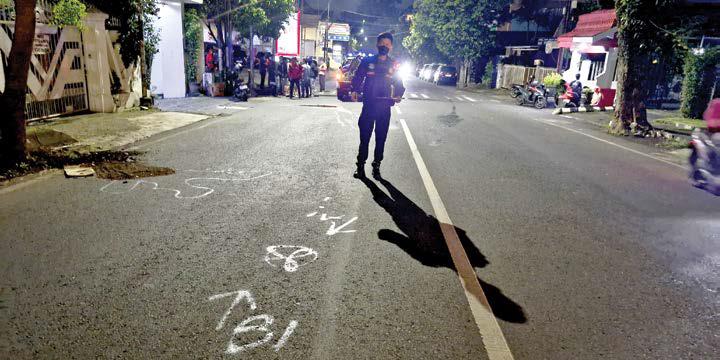 LUKA BERAT: Polisi menandai lokasi kecelakaan antara motor dan mobil di Jalan Mayjen. Panjaitan, Kecamatan Klojen, Kota Malang, kemarin pagi.