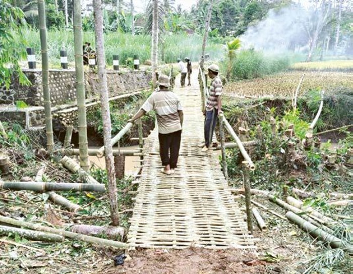 BUKA AKSES: Warga membangunkan jembatan darurat di Desa Sumberoto, Kecamatan Donomulyo untuk akses mobilitas warga selama perbaikan jembatan belum rampung.