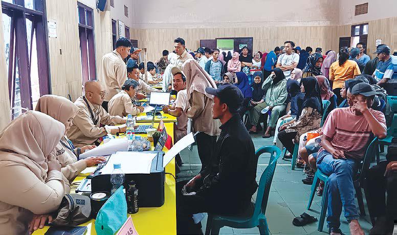 TERTIB BAYAR PAJAK: Petugas dari Bapenda Kabupaten Malang melayani warga yang membayar pajak di Balai Desa Pujon Lor, Kecamatan Pujon