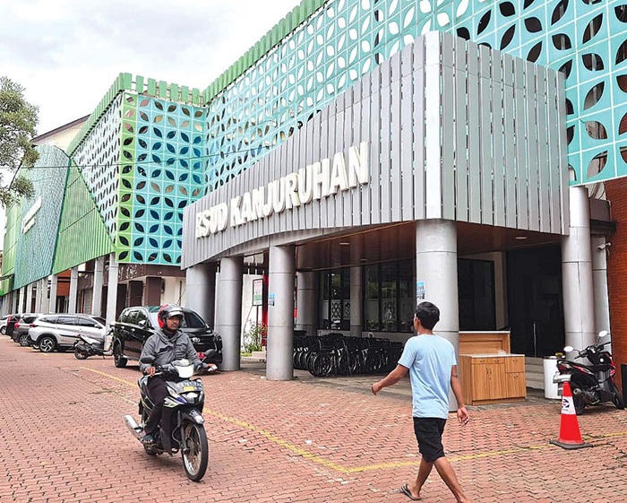 FASILITAS KESEHATAN: Pengunjung berjalan di depan RSUD Kanjuruhan, Kepanjen. RSUD Kanjuruhan menjadi salah satu RS rujukan untuk pasien porprov.