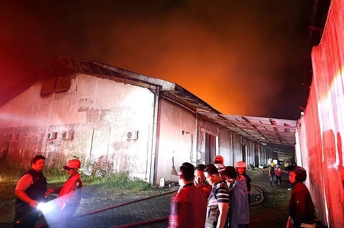 API MEMBUBUNG TINGGI: Tim Pemadam Kebakaran Kabupaten Malang bersiap memadamkan api yang membakar Pabrik Rokok Atlas di Jalan Raya Genengan, Kecamatan Pakisaji, Jumat malam (23/5).