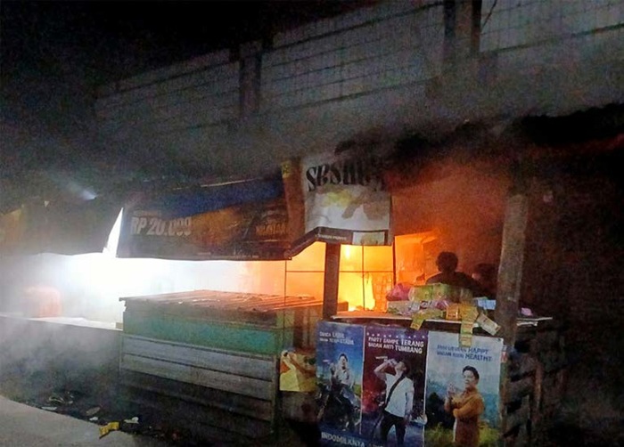 AKIBAT PANAS LAMPU: Api terlihat membara di dalam bedak milik Abdurrohim di Pasar Singosari, Desa Pangetan, Kecamatan Singosari, Jumat malam (23/5).