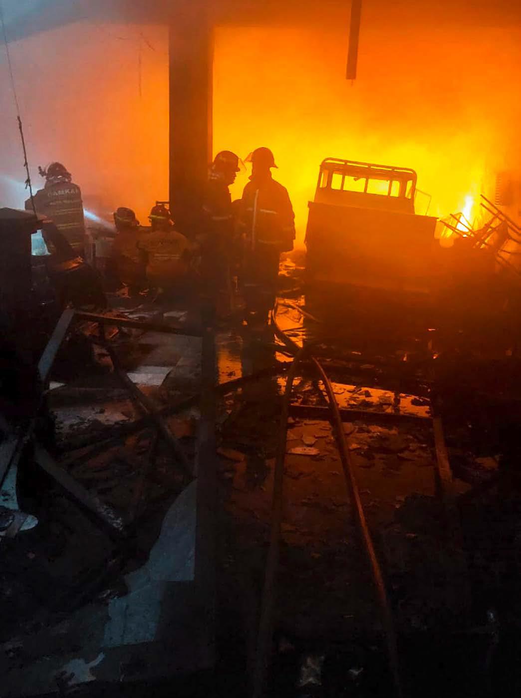 EMPAT MOBIL TERBAKAR: Petugas berupaya memadamkan api di lantai satu toko aksesori mobil di Jalan Simpang Wilis, Klojen, kemarin pagi. Total ada tujuh unit mobil damkar yang diterjunkan ke lokasi.