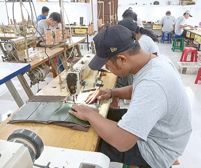 PRODUK LOKAL: Pekerja di CV Alfi Leather, Desa Jatirejoyoso, Kecamatan Kepanjen menjahit kulit menjadi dompet yang bagus.