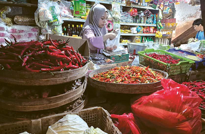 KOMODITAS: Intan, salah satu pedagang cabai di Pasar Kepanjen melayani pelanggannya kemarin (30/5). Menjelang Hari Raya Idul Adha, harga pokok penting (bapokting) di pasar tradisional masih stabil.