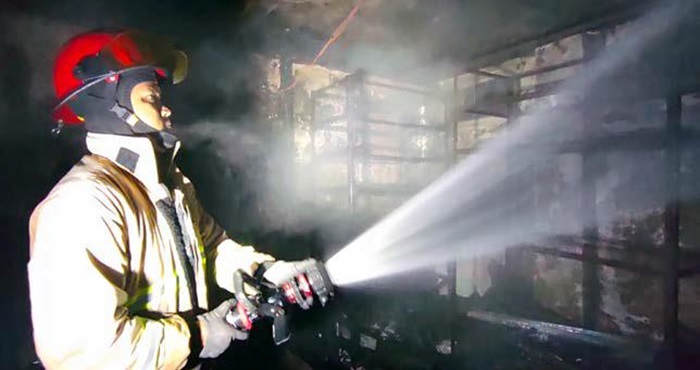 PASTIKAN API PADAM: Personel Damkar Kota Malang menyemprotkan air di titik api yang menghanguskan apotek Jalan Budi Utomo, Kelurahan Mulyorejo, Kecamatan Sukun pukul 02.58 dini hari kemarin (31/5).