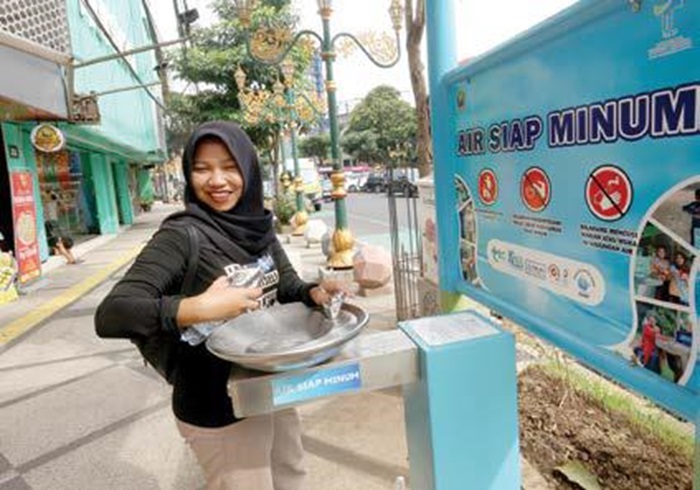 SIAP MINUM: Seorang wisatawan Kajoetangan Heritage mengisi ulang botol miliknya di anjuang air siap minum.