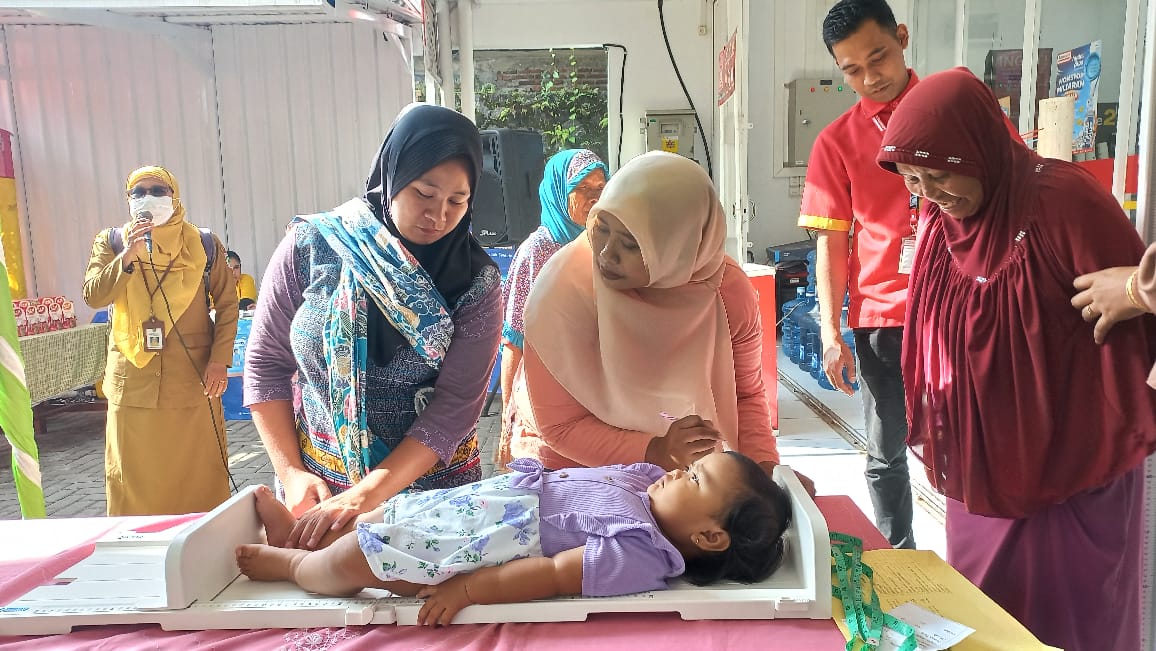 TIMBANG BADAN: Petugas Posyandu menimbang badan anak balita dalam acara Posyandu dan edukasi nutrisi di Desa Ardimulyo, Singosari, Senin (2/6)