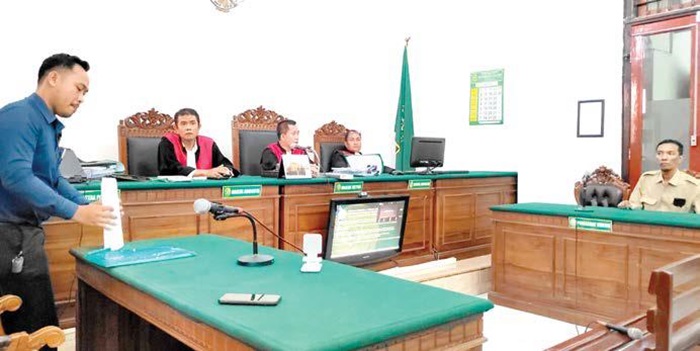 UPAYA HUKUM: Denny Mercury Lumban Gaol (kiri) hendak menyerahkan berkas gugatan kepada majelis hakim di PN Sursbaya kemarin (3/6).
