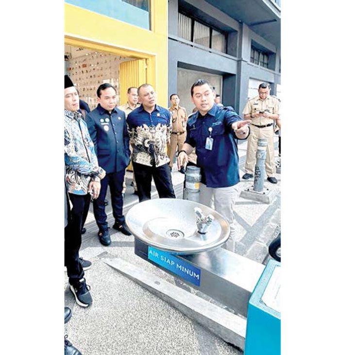 TINJAU LANGSUNG: Dirut Perumda Tugu Tirta Proyo Sudibyo (kanan) menjelaskan cara kerja anjungan air siap minum kepada DPRD Jatim kemarin.