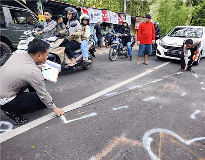 TRAGIS: Petugas dari Polresta Malang Kota memberi tanda untuk lokasi kecelakaan di Jalan Laksda Adi Sucipto, Kelurahan Pandanwangi, Kecamatan Blimbing, kemarin siang (9/6).