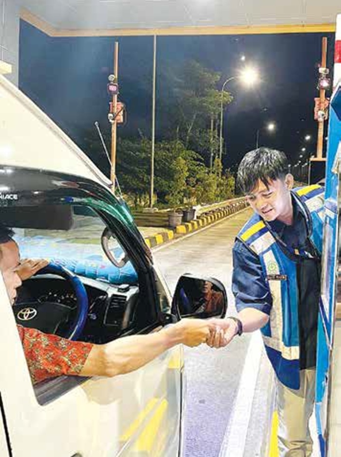 LAYANAN: Petugas PT Jasa Marga Pandaan-Malang membantu pengendara di gerbang tol Singosari kemarin.