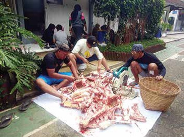 BERBAGI: Hewan kurban yang sudah disembelih kemudian dipotong menjadi puluhan paket untuk dibagikan ke masyarakat yang membutuhkan.