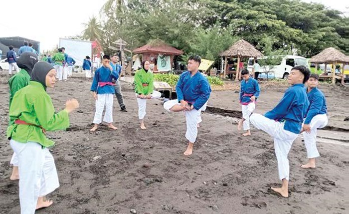 ASAH KEMAMPUAN: Atlet Kurash Kota Malang melakukan pemanasan sebelum bertanding di Pantai Cacalan, Kecamatan Kalipuro, Kabupaten Banyuwangi pekan lalu.