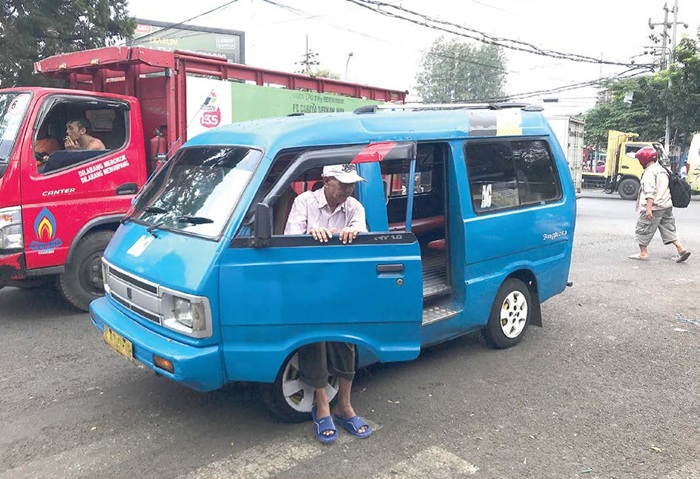 BAKAL JADI FEEDER: Seorang penumpang turun dari angkot di kawasan Pasar Gadang kemarin siang.