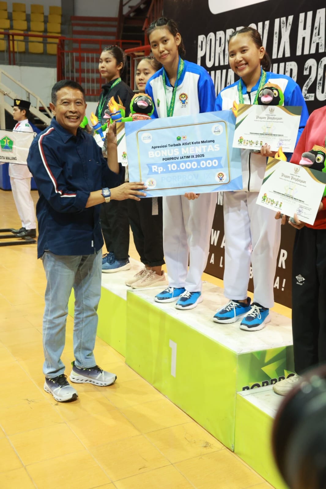 BAHAGIA: Wahyu saat menyerahkan Bonus Mentas sebesar Rp 10 juta bagi atlet peraih medali emas dari Kota Malang