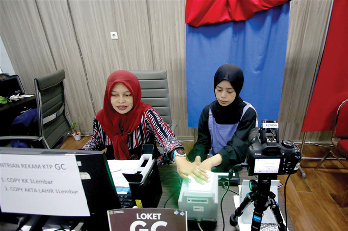 LAYANAN PUBLIK: Petugas Dispendukcapil Kota Malang melayani warga yang mengurus cetak E-KTP dan aktivasi IKD kemarin.