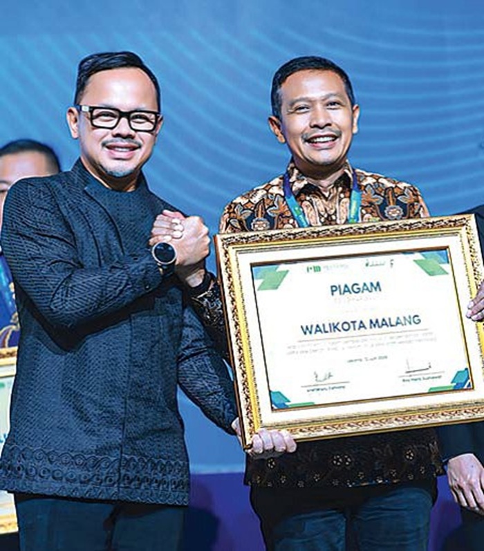 PERTAMA DALAM 10 TAHUN: Wamendagri Bima Arya (kiri) menyampaikan penghargaan kepada Wali Kota Malang Wahyu Hidayat di Jakarta, kemarin.
