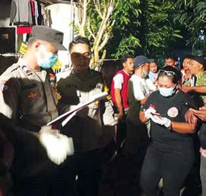 DIDUGA KOMPLIKASI: Petugas dari Polres Malang mengevakuasi jenazah Anna Fonny L, 58, di rumahnya jalan Melon, RT 4 RW 1 Dusun Tambaksari, Desa Jatisari, Kecamatan Tajinan.