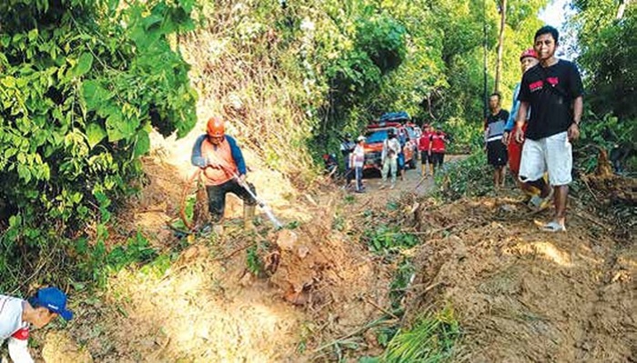 BERUSAHA KERAS: Sejumlah warga melakukan pembersihan jalan di Desa Pujiharjo, Kecamatan Tirtoyudo akibat banjir pada Jumat (13/6) sampai Sabtu (14/6) lalu.