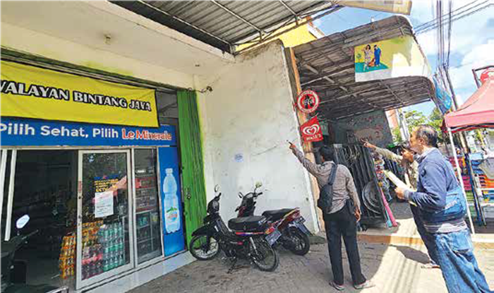 IDENTIFIKAS I PELAKU: Petugas dari Polsek Gondanglegi melakukan olah TKP di depan swalayan Jalan Raya Hayam Wuruk, Desa Gonanglegi Wetan, Kecamatan Gondanglegi kemarin.