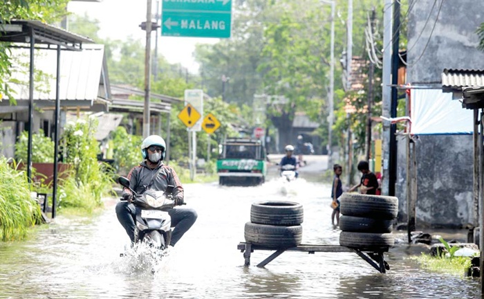 BISA DILEWATI: Warga melintas di Jalan Kalitengah kemarin (17/6). Genangan terjadi akibat hujan yang mengguyur kawasan itu Senin (16/6) malam hingga dini hari kemarin (17/6).