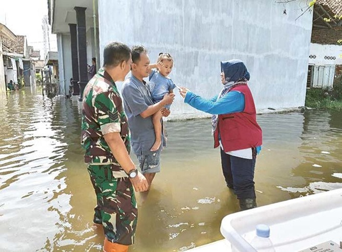 CEK KESEHATAN: Petugas Puskesmas Tanggulangin (kanan) memberikan vitamin kepada anak-anak terdampak banjir di Desa Boro, Selasa (18/6).