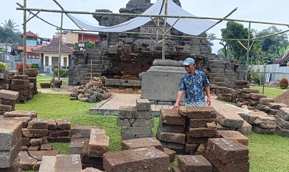 BERSEJARAH: Seorang pekerja memeriksa bebatuan Candi Jago yang sudah ditandai kemarin (20/6). Penandaan untuk memudahkan pemasangan kembali.