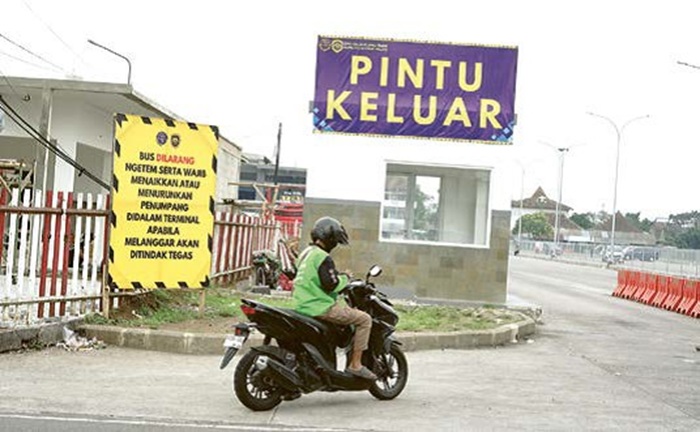 LEBIH TERTATA: Seorang pengemudi ojek online berhenti memeriksa notifikasi pesanan di pintu keluar Terminal Arjosari.