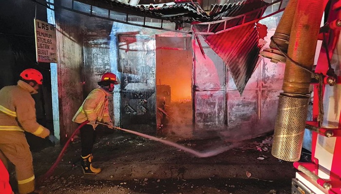 SIGAP: Tim Damkar Kabupaten Malang menyemprotkan air untuk memadamkan kobaran api. Petugas membutuhkan waktu satu jam untuk memadamkan api yang membakar bengkel las di Desa Saptorenggo, Kecamatan Paki