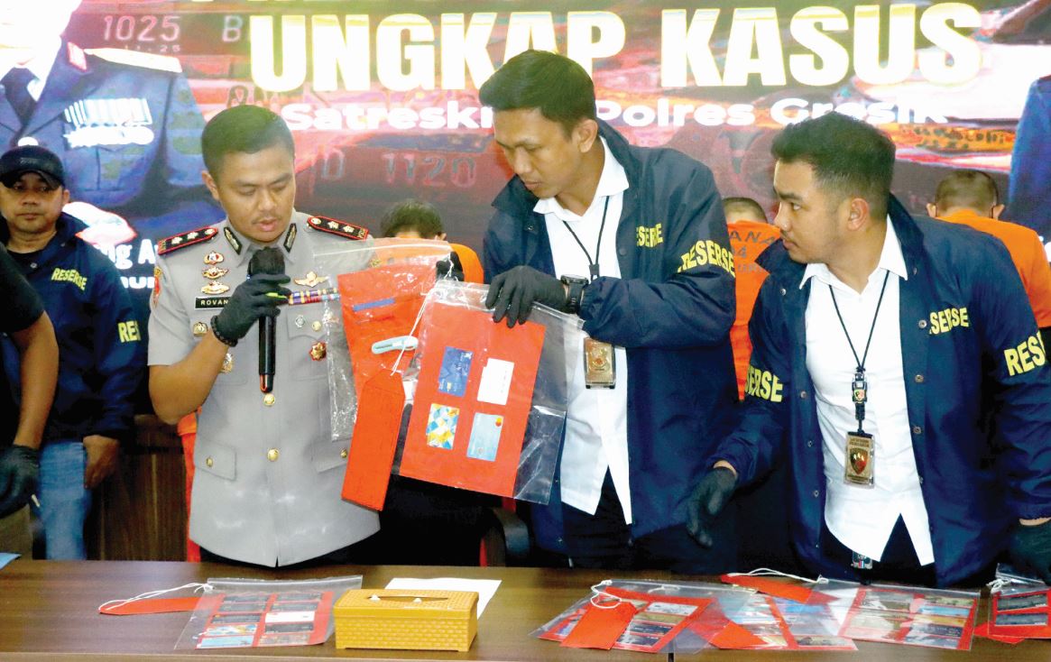 LAKUKAN PENDALAMAN: Kapolres Gresik AKBP Rovan Richard Mahenu (kiri) menunjukan barang bukti hasil kejahatan lima tersangka ganjal mesin ATM saat ungkap kasus Senin (23/6) lalu.