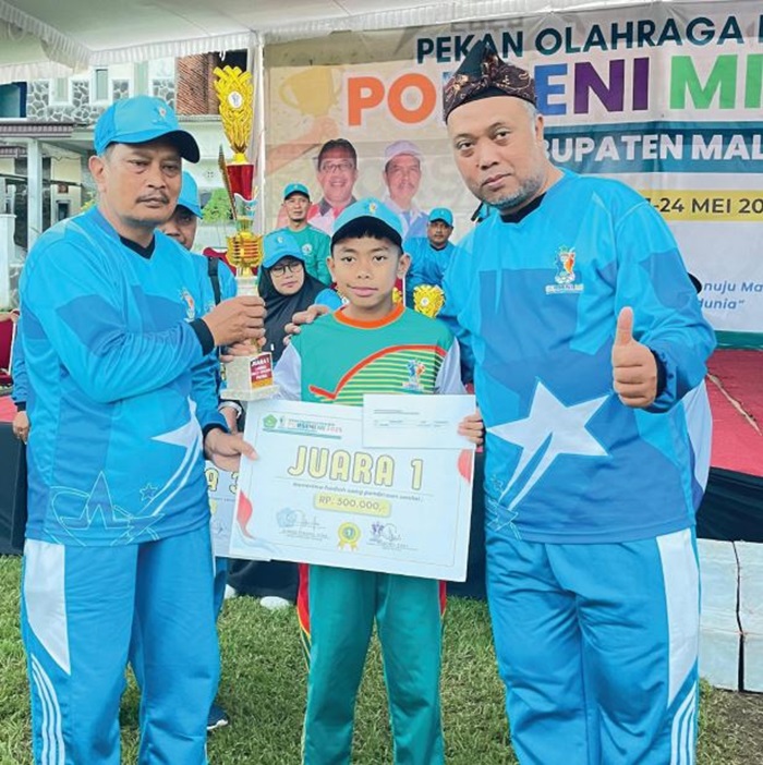 BERPRESTASI: Siswa MI Mambaul Ulum Tirtomoyo, Pakis, Ahmad Retowansyah (tengah) menerima hadiah dan plakat juara bulu tangkis Porseni MI tingkat Kabupaten Malang beberapa waktu lalu.