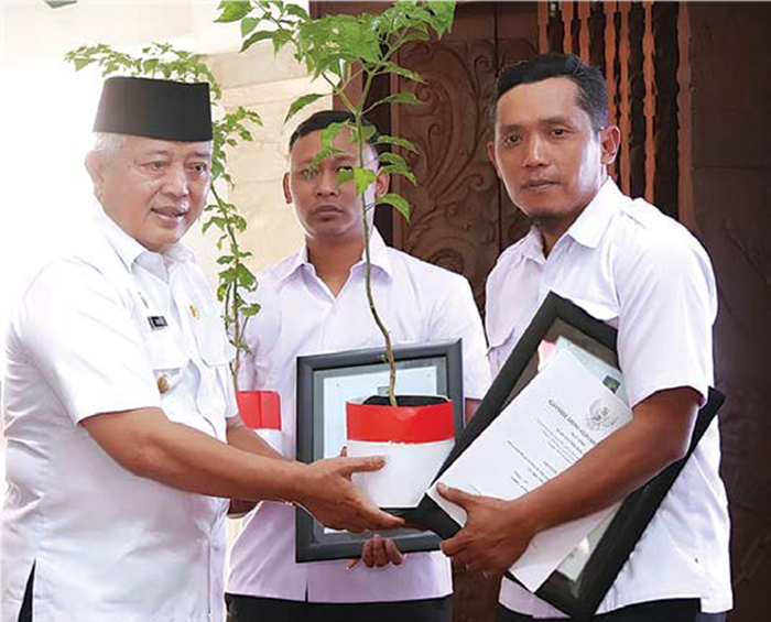 SIMBOLIS: Bupati Malang H M. Sanusi (kiri) menyerahkan bingkisan berisi bibit cabai kepada pengurus Kopdeskel Merah Putih di pendapa Agung Kabupaten Malang.