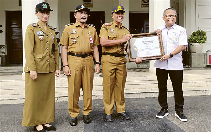MEMBANGGAKAN: Kepala BPJS Ketenagakerjaan Cabang Malang Zulkarnain Mahading (kanan) menyerahkan penghargaan khusus terkait capaian UCJ kepada Sekda Kota Malang Erik Setyo Santoso kemarin.