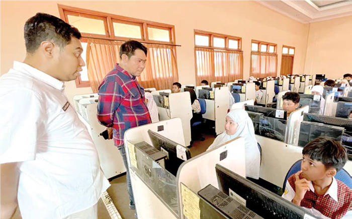 MEMANTAU: Wakil Ketua DPRD Gresik Lutfi Dhawam (kiri) meninjau pelaksanaan TPA SPMB yang berlangsung di SMPN 1 kemarin (2/7).