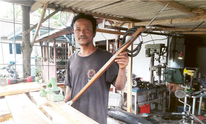 TELATEN: Mahoni menunjukkan contoh speargun custom di kediamannya di Dusun Ledok, Desa Banjarejo, Kecamatan Donomulyo, Kabupaten Malang, 28 Juni lalu.
