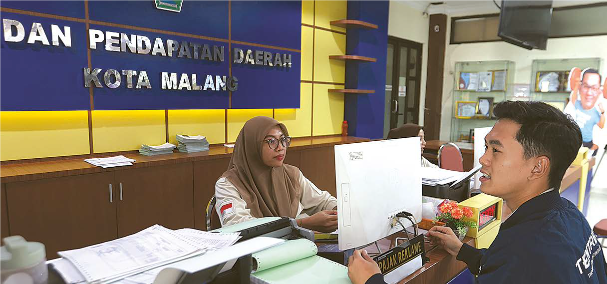 RINGANKAN BEBAN: Petugas Bapenda Kota Malang melayani masyarakat berpenghasilan rendah (MBR) yang mengurus BPHTB kemarin.